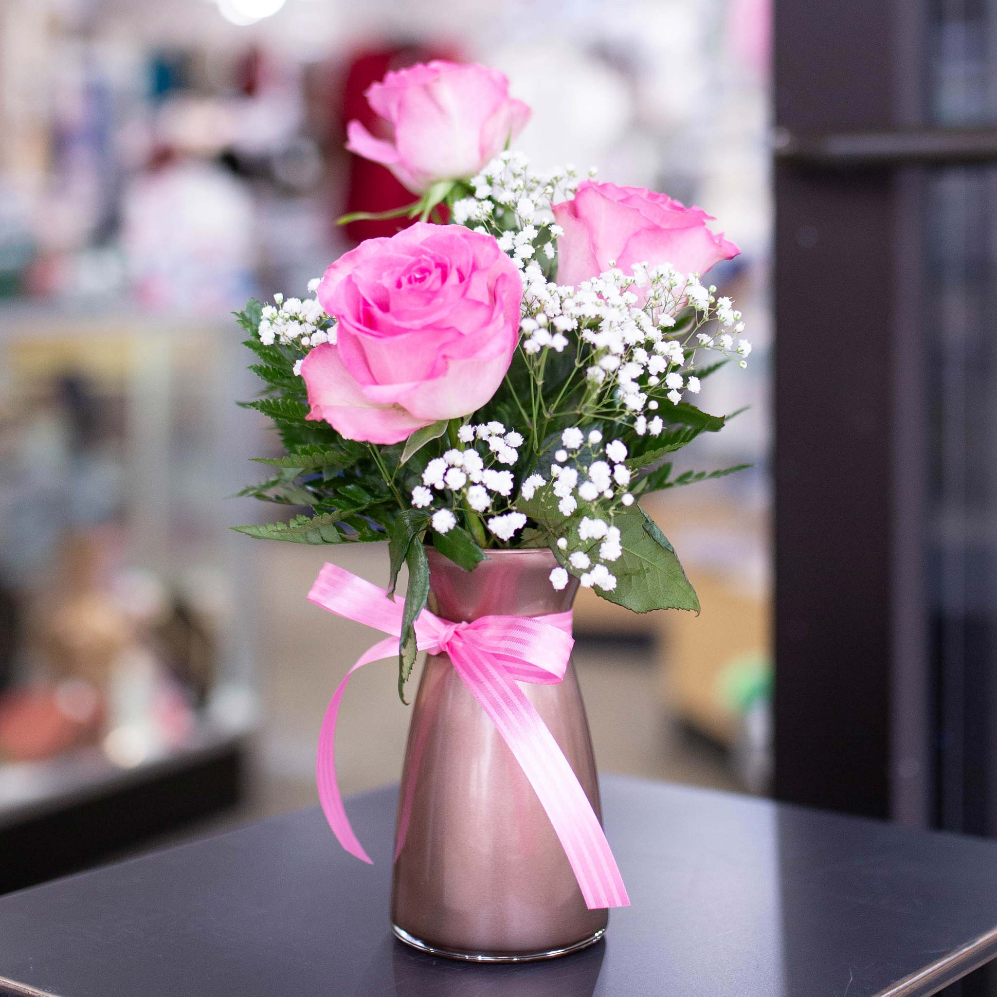 Pink roses in a vase with ribbon